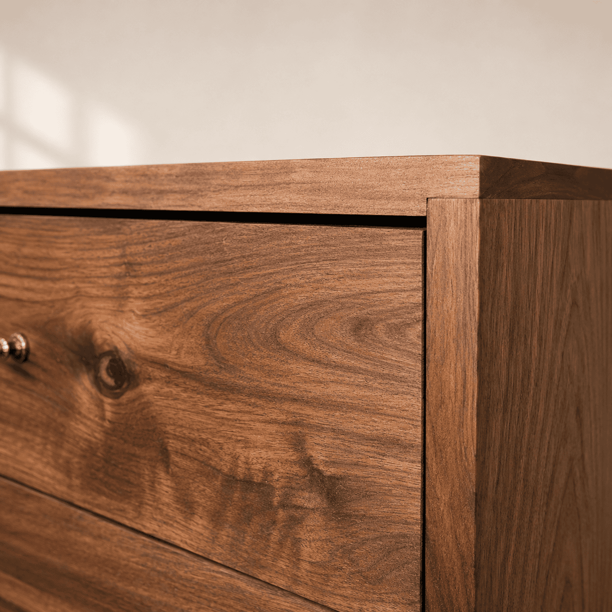 Close-up of handcrafted walnut dresser joinery highlighting solid wood construction, seamless craftsmanship, and natural walnut grain.