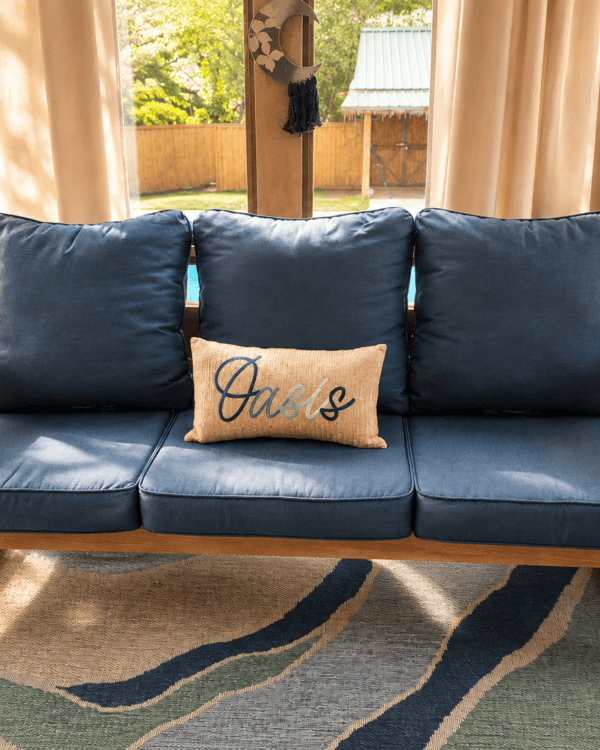 Front view of a handcrafted solid wood sofa with blue cushions and clean modern lines.