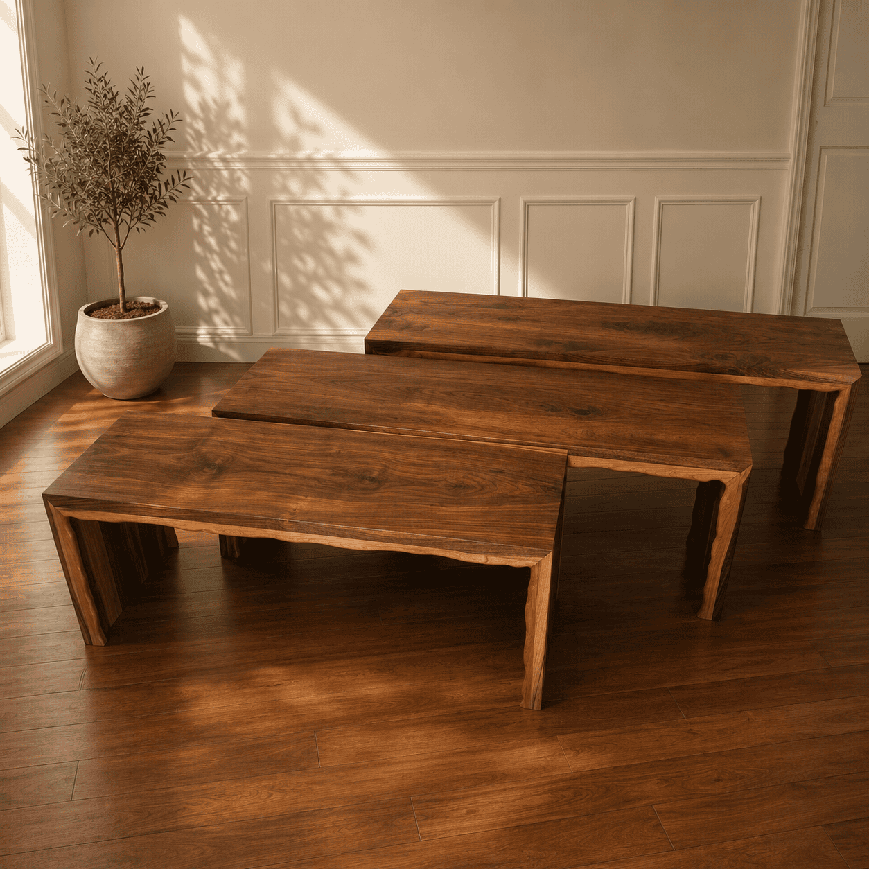 Three handcrafted live edge walnut waterfall benches in graduated sizes displayed in a warm modern interior.