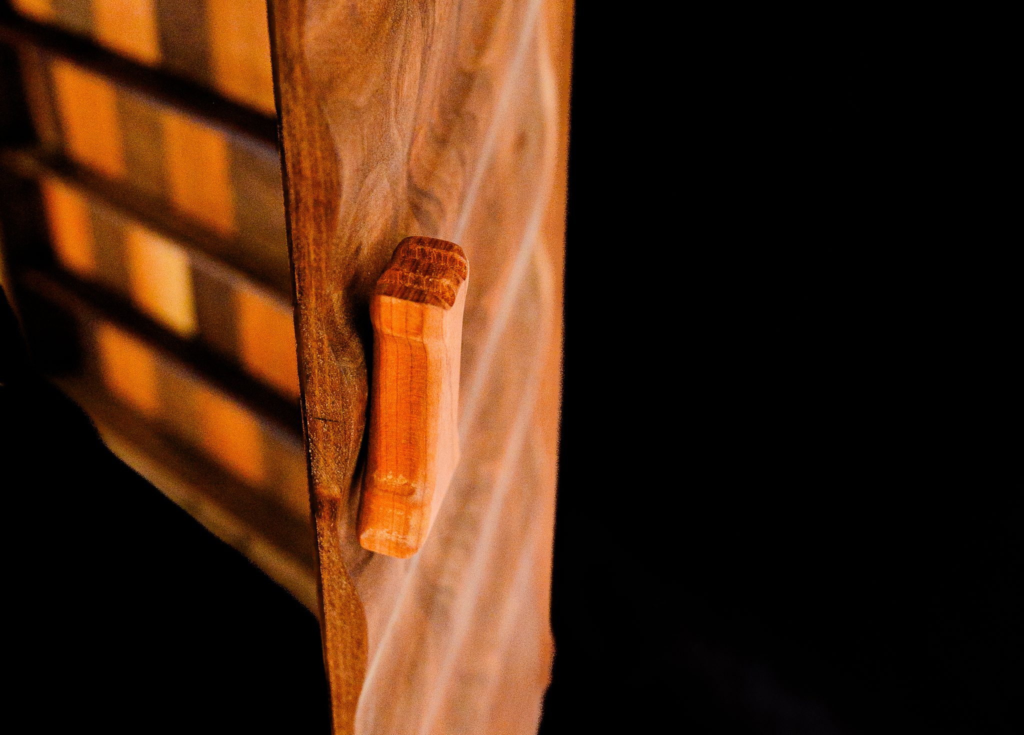 Detail view of folding walnut chessboard and handcrafted wooden handle
